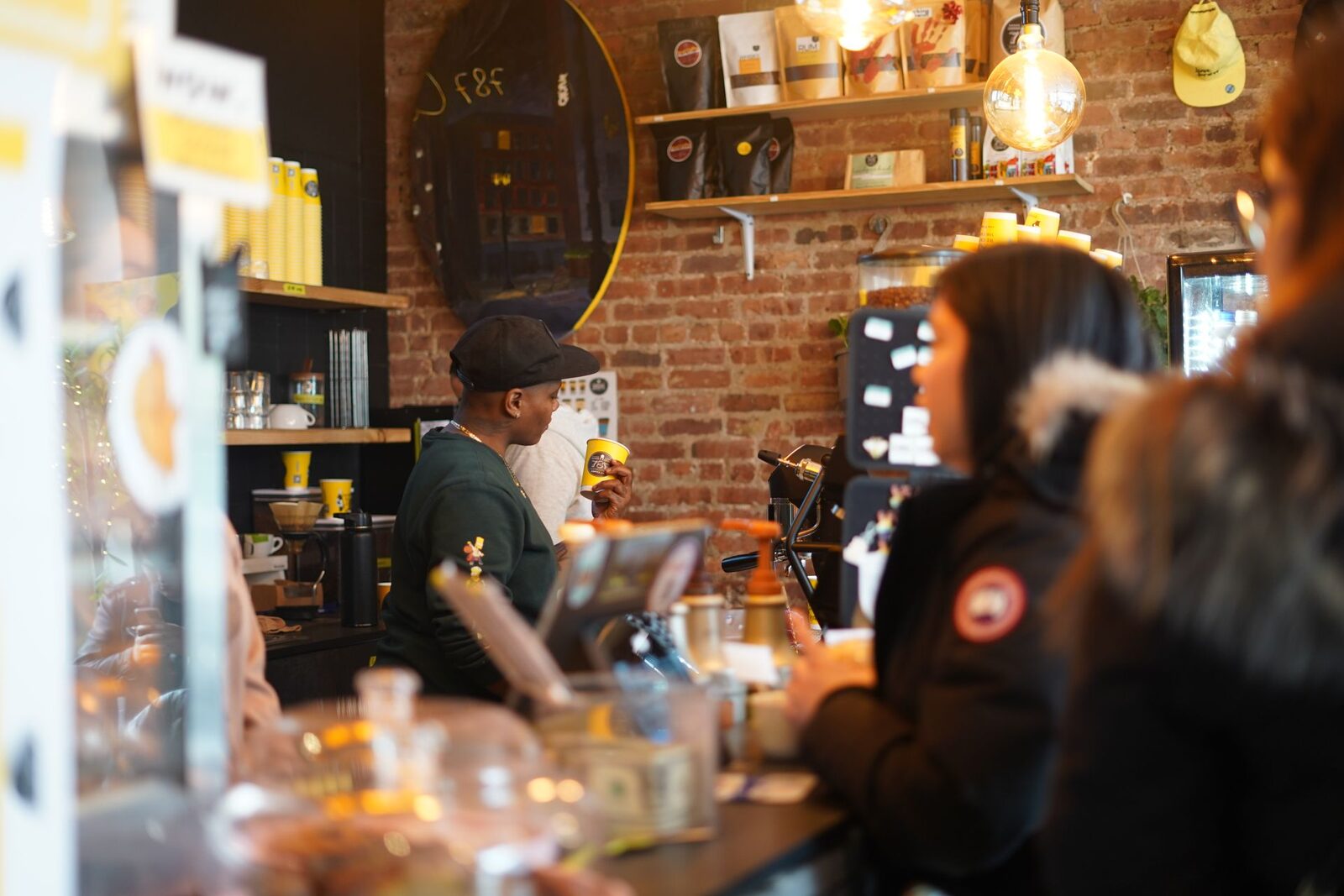 Cafetería con la barra llena de clientes esperando su pedido